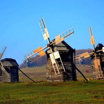 Ancient wooden windmills against a blue sky in the Pirogov Museum in Kyiv
