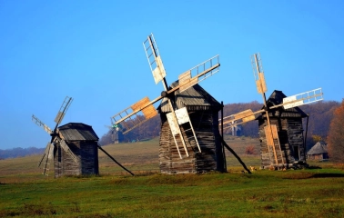 Ancient wooden windmills against a blue sky in the Pirogov Museum in Kyiv