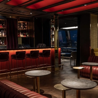 11 Mirrors Restaurant & Bar - sleek modern bar counter with high stools and bottle display