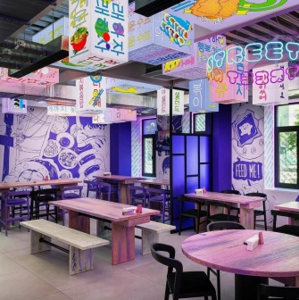 Street Kim - narrow dining space featuring small tables and wooden benches along the wall