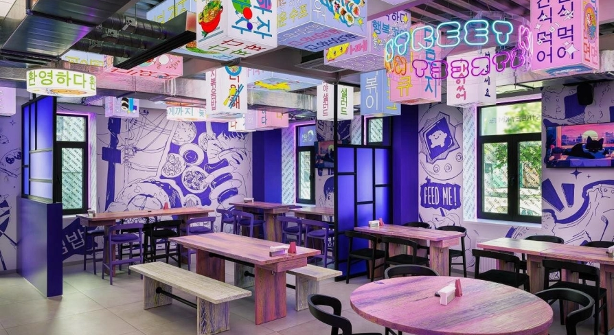 Street Kim - narrow dining space featuring small tables and wooden benches along the wall