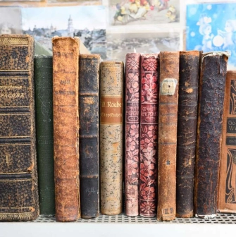 Old books with worn bindings on the shelf of a flea market near Pochaina in Kyiv