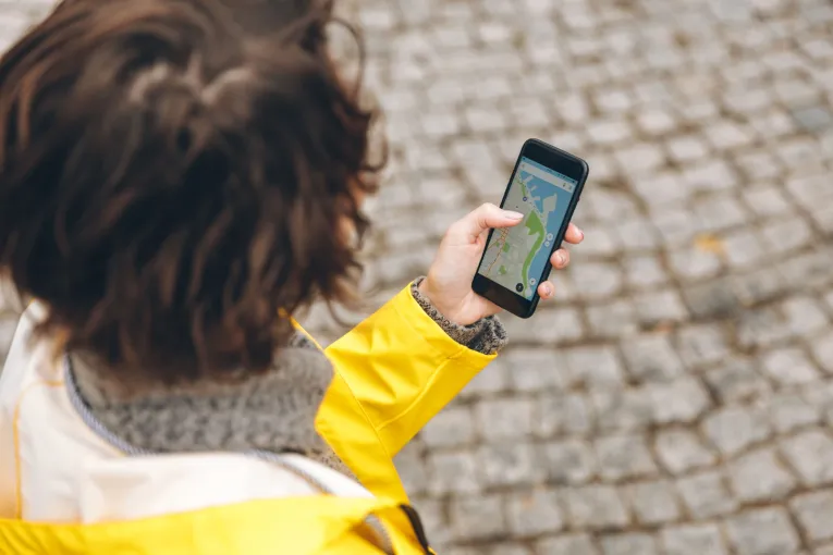 Tourist using a smartphone navigation app while walking in Kyiv