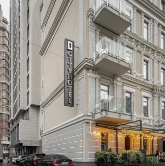 City Hotel in Kyiv - beige hotel building facade with vertical sign and street terrace