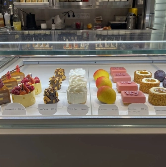 Honey in Kyiv - display case showcasing colorful mousse cakes and fruit desserts