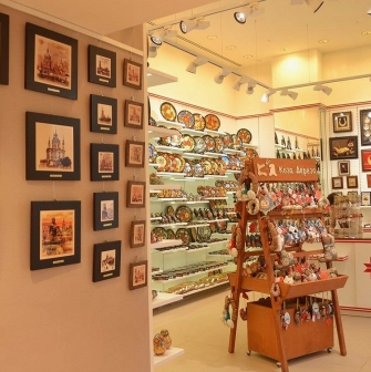 Folkmart in Kyiv - bright shop interior displaying painted plates, framed Kyiv landmark prints, and handmade souvenirs