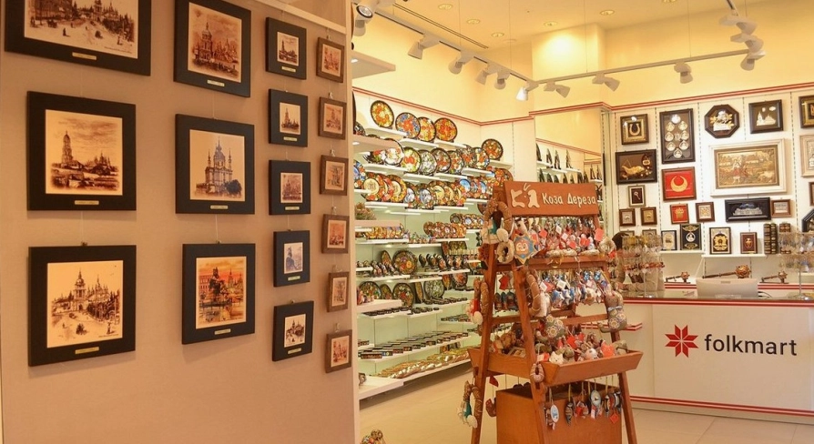 Folkmart in Kyiv - bright shop interior displaying painted plates, framed Kyiv landmark prints, and handmade souvenirs