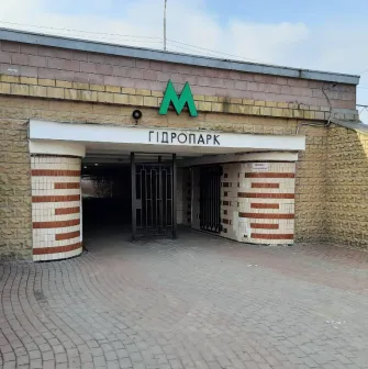 Вхід до станції метро Гідропарк із вивіскою та металевими дверима