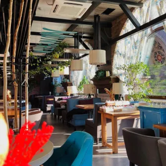 Restaurant Momenty - bright interior with modern lamps and large arched windows