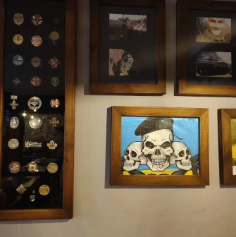 Restaurant wall with framed military awards, photos, and skull art