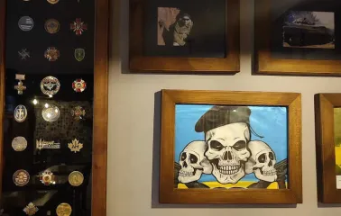Restaurant wall with framed military awards, photos, and skull art