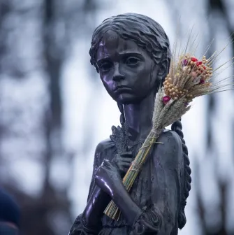 Sculpture of a girl with wheat spikes (Bitter Memory of Childhood) near the Holodomor Memorial