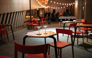 One Love Coffee in Kyiv - evening terrace setting with wine glasses on table and red chairs