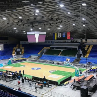 Palats Sportu in Kyiv - brightly lit basketball court parquet surrounded by blue stands
