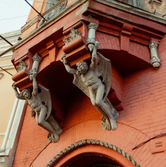 Barons castle in Kyiv - winged stone demons holding the balcony of the red castle