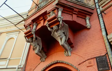Barons castle in Kyiv - winged stone demons holding the balcony of the red castle