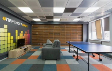 Peremoga Space - room with a console, a sofa and table tennis