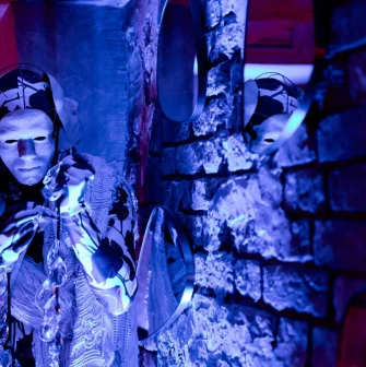 Performer in a white mask with crystals at Alchemist Bar