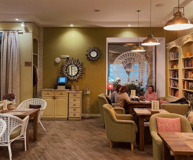 Restaurant Imbyr - relaxed dining room with armchairs bookshelves and people sitting at tables