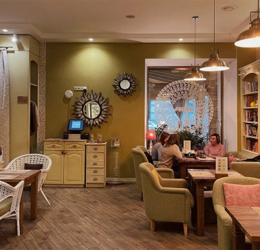 Restaurant Imbyr - relaxed dining room with armchairs bookshelves and people sitting at tables