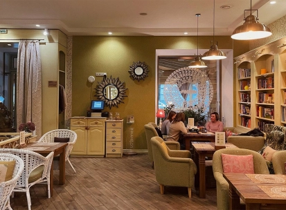 Restaurant Imbyr - relaxed dining room with armchairs bookshelves and people sitting at tables