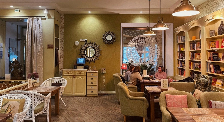 Restaurant Imbyr - relaxed dining room with armchairs bookshelves and people sitting at tables