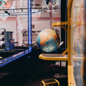 Museum of Mathematics Kuboid in Kyiv - educational exhibit featuring a spinning globe mounted on a yellow stand against a backdrop of technical diagrams