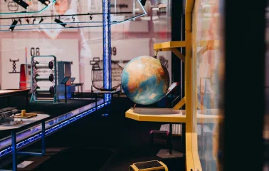 Museum of Mathematics Kuboid in Kyiv - educational exhibit featuring a spinning globe mounted on a yellow stand against a backdrop of technical diagrams