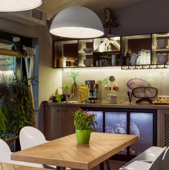 Ulyublenyi Diadia – cozy dining area with plants and open kitchen shelves