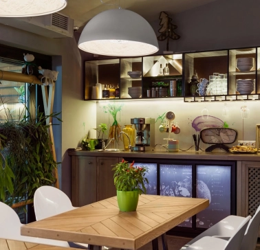 Ulyublenyi Diadia – cozy dining area with plants and open kitchen shelves