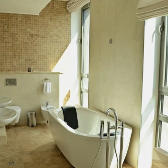 City Hotel in Kyiv - bright bathroom with freestanding white tub and panoramic window