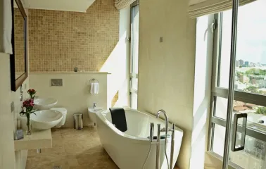City Hotel in Kyiv - bright bathroom with freestanding white tub and panoramic window
