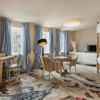 Vozdvyzhenskyi in Kyiv - room featuring canopy bed, blue curtains and patterned carpet