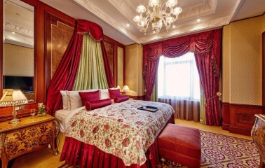 Luxurious room at the Fairmont Grand Hotel in Kyiv with red decoration and classic interior