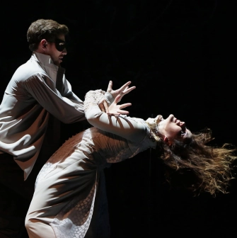 Teatr Lesi Ukrainky in Kyiv - dramatic scene featuring an actor in a mask holding a woman in a white dress