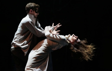 Teatr Lesi Ukrainky in Kyiv - dramatic scene featuring an actor in a mask holding a woman in a white dress