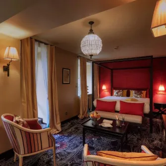 Vozdvyzhenskyi in Kyiv - hotel room with red walls, canopy bed and sitting area
