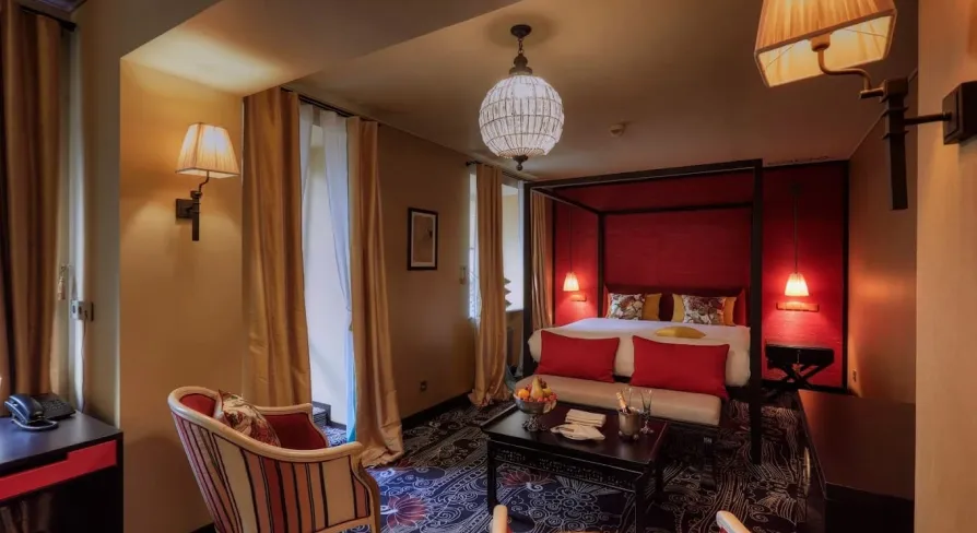 Vozdvyzhenskyi in Kyiv - hotel room with red walls, canopy bed and sitting area