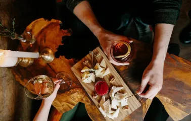 Bar Restaurant Kosatka - close-up of a cheese plate wine and a candle on a rustic wooden table