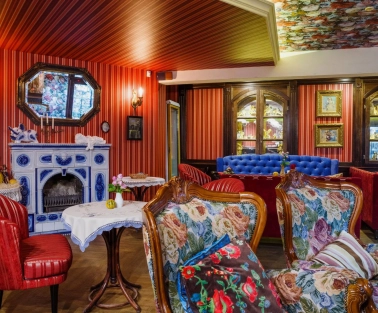 Restaurant Za Dvoma Zaicyamy - dining room with varied seating a sofa and a decorative fireplace