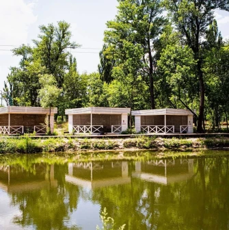 X-Park in Kyiv - cozy wooden gazebos for recreation standing on the river bank surrounded by green trees