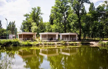 X-Park in Kyiv - cozy wooden gazebos for recreation standing on the river bank surrounded by green trees