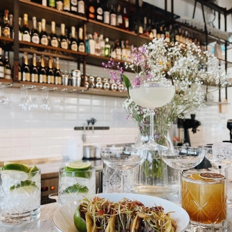 Milk Bar Tsum - close-up view of two tacos with savory fillings and garnish
