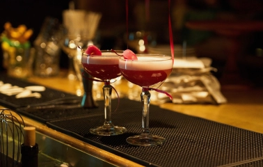 Tisto Syr i Titka Bella – two pink cocktails with foam and petals on bar counter