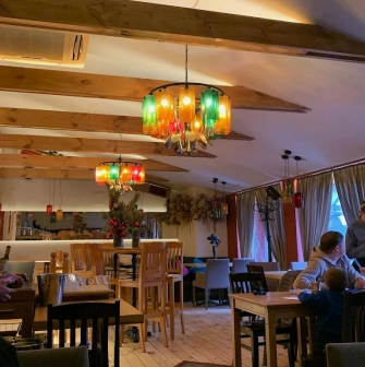 Restaurant Mama Focaccia & Papa Chacha - cozy interior with wooden beams and colorful bottle chandeliers