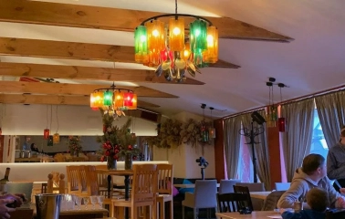 Restaurant Mama Focaccia & Papa Chacha - cozy interior with wooden beams and colorful bottle chandeliers