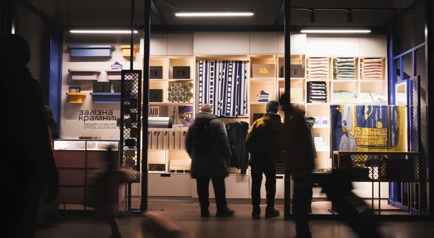 Zalizna Kramnytsia in Kyiv - a shining showcase of a souvenir shop filled with goods and silhouettes of customers