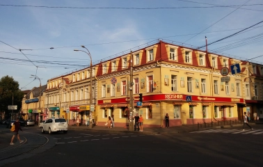 Verkhnii Val in Kyiv - sunny street corner with a yellow historical building hosting a Roshen shop