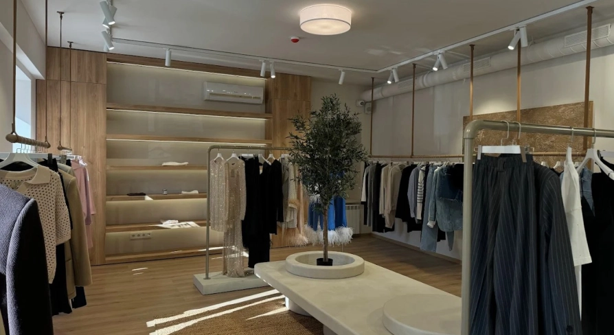 Concept 1 Boutique in Kyiv - spacious showroom interior designed in beige tones with a decorative olive tree in the center
