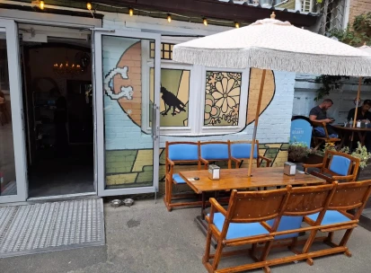 OG Burger in Kyiv - terrace with wooden tables and white umbrella